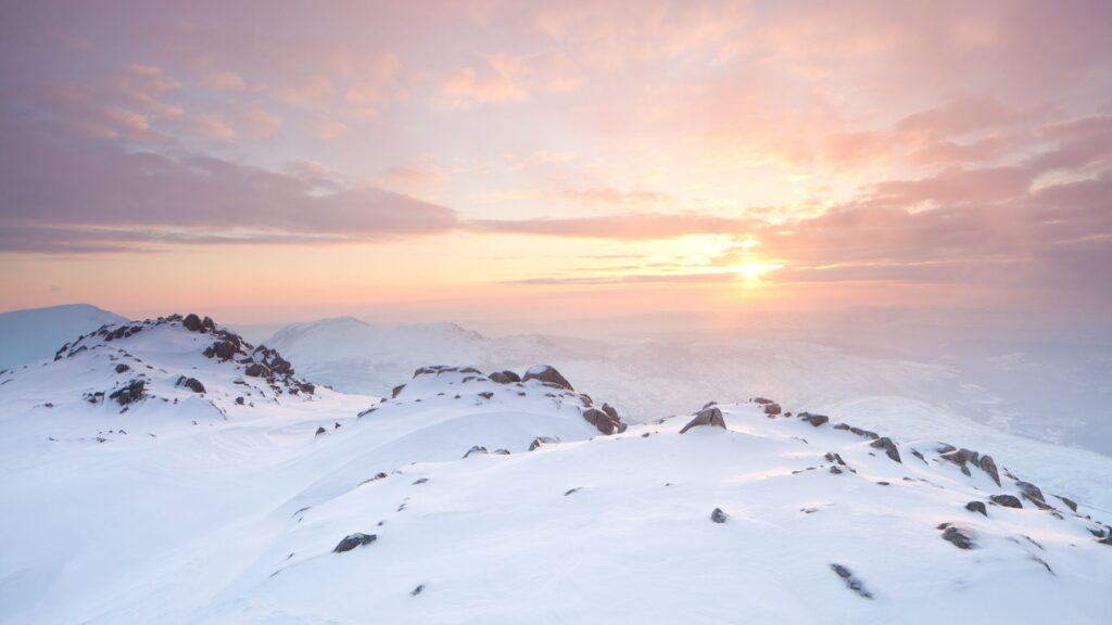 Sun setting over snowdonia, north wales, creating a breathtaking winter landscape.