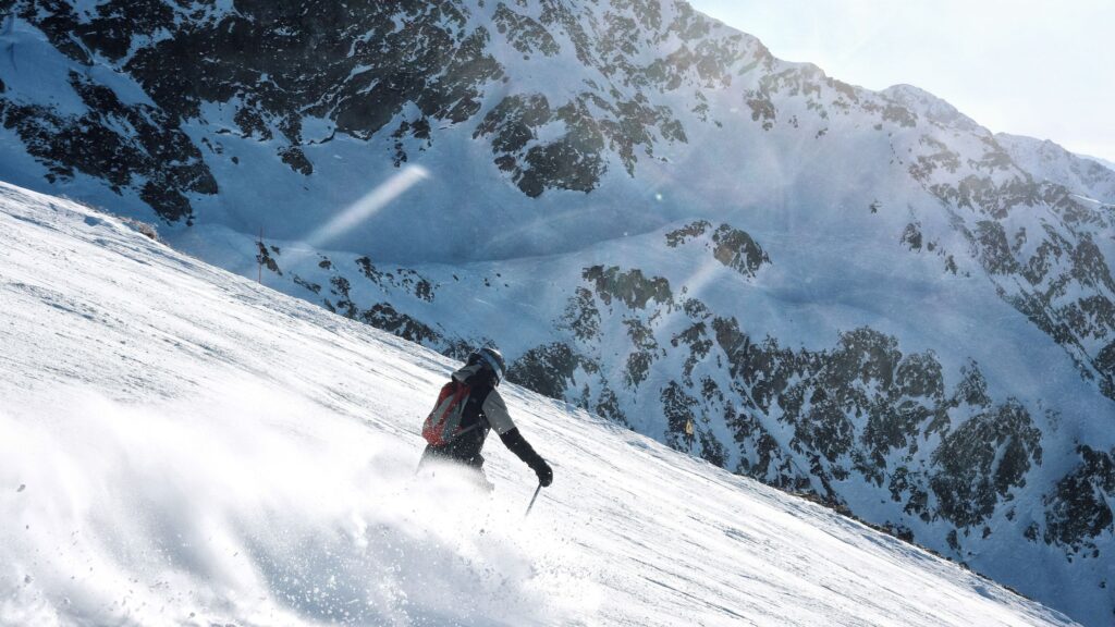 Skier gliding down snowy mountain slope